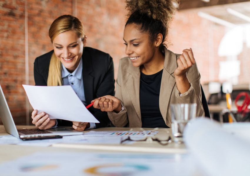 two residential property managers sitting at a desk looking over documents